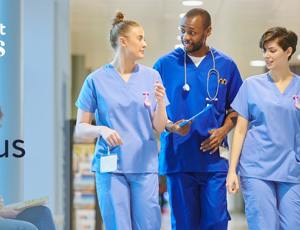 Healthcare staff walking through a hospital corridor wearing medical scrubs